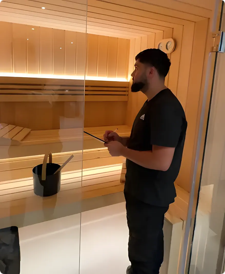 Artisan Zen Sauna vérifiant l'intérieur d'un sauna installé dans une maison à Genève