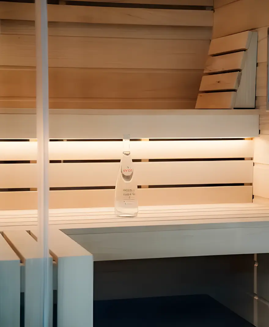 Intérieur d'un sauna Nexus, bouteille d'eau en verre posée sur la banquette