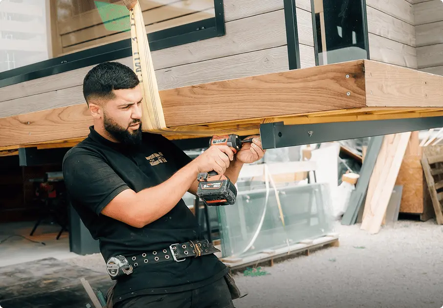Ouvrier Zen Sauna réalisant les finitions d'un sauna suspendu à une grue